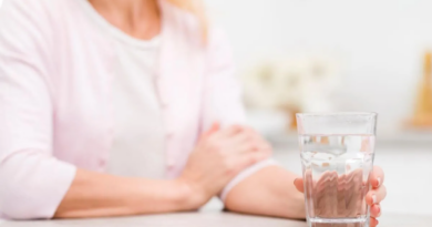 A person holding a glass of water, symbolizing the importance of hydration and promoting the habit of staying hydrated for overall health and well-being.